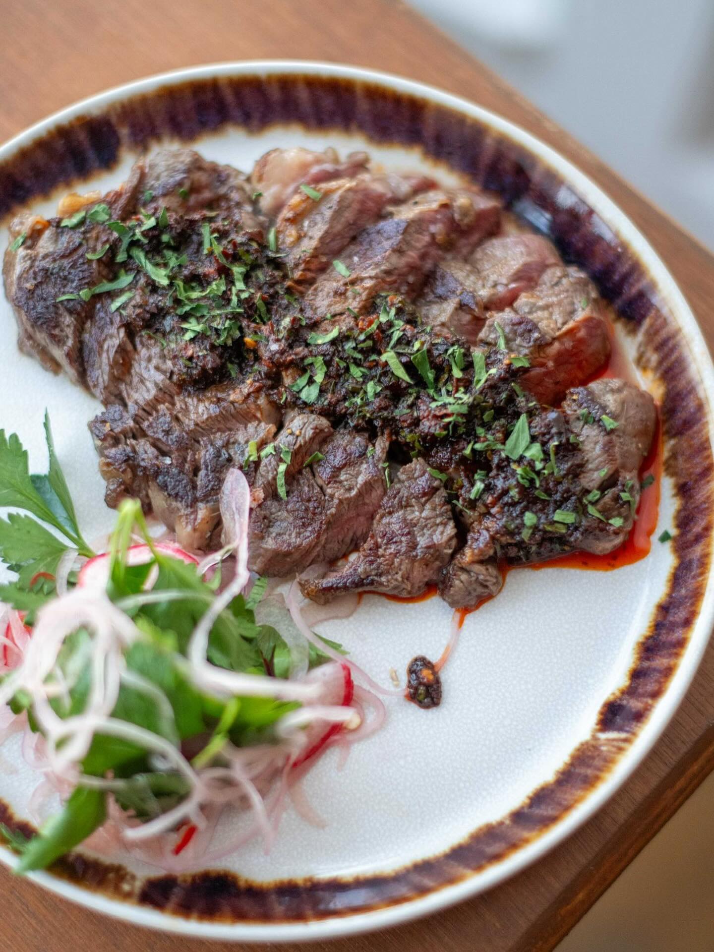A plated beef dish with herbs